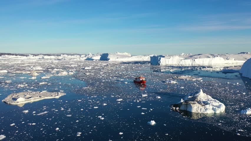 Boat float in frozen winter water landscape among ice shore. Excursion boat in the ocean surrounded by icebergs. Boat in Antarctica ocean. Tourism, explore Antarctic Peninsula.