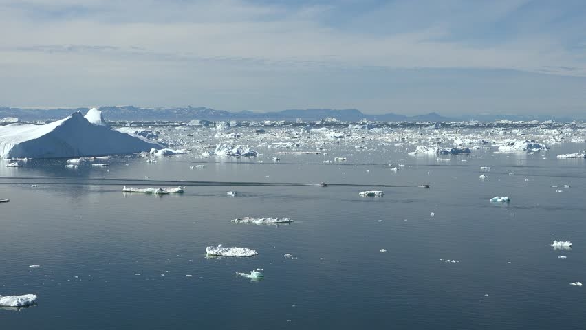 Boat float in frozen winter water landscape among ice shore. Excursion boat in the ocean surrounded by icebergs. Boat in Antarctica ocean. Tourism, explore Antarctic Peninsula.