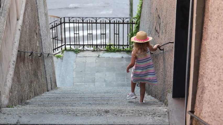 Little girl going down the city stairs.