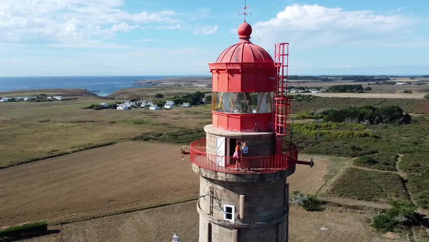 Aerial view of the Goulphar lighthouse on the island of Belle-île-en-mer in Morbihan, France - The tallest lighthouse on the biggest island of Brittany is adorned with a red metallic dome Royalty-Free Stock Footage #3433222107