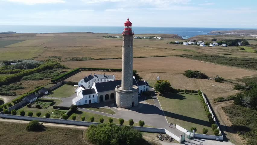 Aerial view of the Goulphar lighthouse on the island of Belle-île-en-mer in Morbihan, France - The tallest lighthouse on the biggest island of Brittany is adorned with a red metallic dome Royalty-Free Stock Footage #3433222137