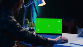 Teleworker in living room office using chroma key laptop to analyze sales report and plan business development. Remote worker doing project research, typing on green screen device keyboard - Powered by Shutterstock - Get 15% off with code: PIKWIZARD15