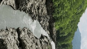 Belaya river between slopes of summer mountains, Adygea, Caucasus Mountains. Vertical video