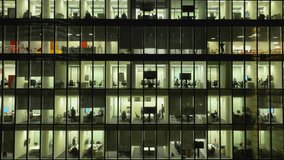 People working late night office windows view on business center building in 4k - Powered by Shutterstock - Get 15% off with code: PIKWIZARD15