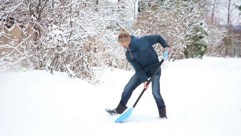young man with the shovel clears snow, then drops shovel and goes away