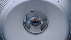 Close up shot of a female patient lying on CT, PET, or MRI scan bed, moving inside the machine. High-tech equipment scans patient body and brain in a medical facility with cutting-edge technologies. - Powered by Shutterstock - Get 15% off with code: PIKWIZARD15
