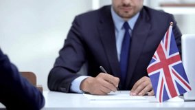 Business contract between country britain Signing The Document Judge giving document with contract to woman to sign in financial agreement closeup of lawyer,