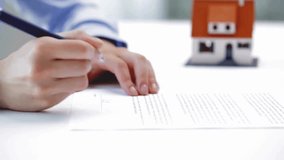 Businessman signing contract at table signature with house model using ballpen Man Filling In The Tax Form Financial manager approving Businessman