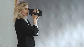 stylish woman films with a VHS camera in the studio