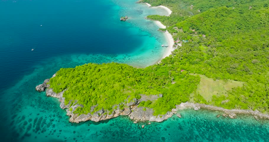 Rocky coastal with turquoise water and sandy beach in Cobrador Island. Romblon, Philippines.