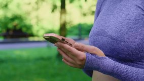 Close up of woman in sportswear browsing a mobile phone