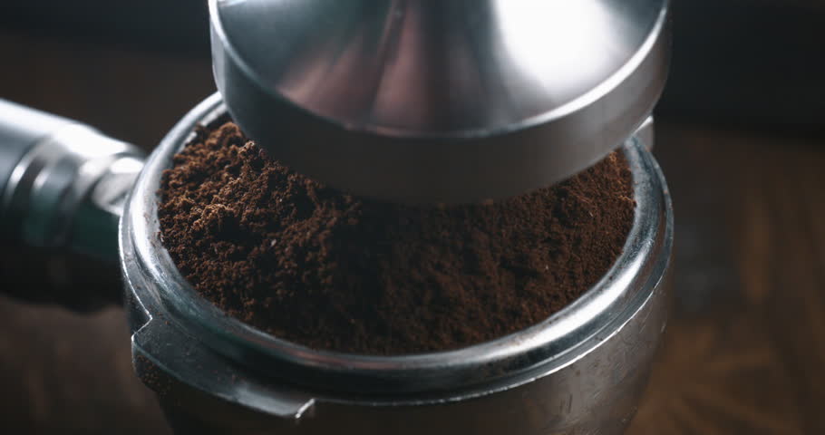 Super slow motion macro of barista preparing espresso with portafilter and tamper with fresh flavorful aromatic roasted ground coffee powder at 1000 fps in cafeteria for serving it to customer. Royalty-Free Stock Footage #3433764797
