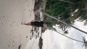 Man walks on beach journey of well-being vertical video Man walks on beach brings him closer to tranquility. Man walks on beach his heart aligning with rhythmic waves of success in tropical nature.