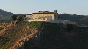 Drone shot of private vineyards and winery located in Malibu mountains, California, USA. Malibu Rocky Oaks Estate Vineyard residence at the sunset. Wine industry and business concept, 4k footage