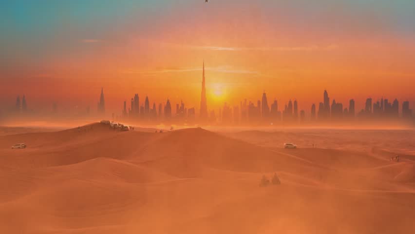 Group of people in a desert looks on the landing plane with Dubai city silhouette at epic sunset.