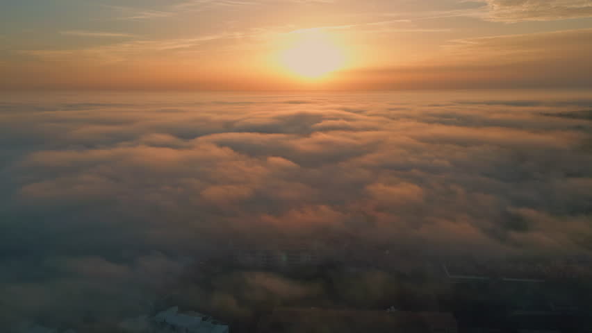 Golden sun setting down over fluffy clouds covering nature. Aerial view idyllic bright sunset illuminating cloudy sky horizon. Picturesque yellow sunlight shining at white dense fog. Dawn concept. Royalty-Free Stock Footage #3433967787