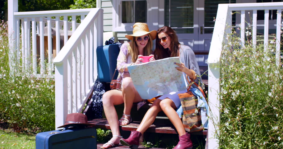 Friends, map and women in home for travel on holiday, vacation and trip destination. Happy, excited and people with paper for navigation, location and planning decision for journey, explore and fun