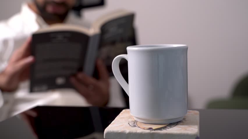 Senior man reading a book in public library, turning pages, doing research