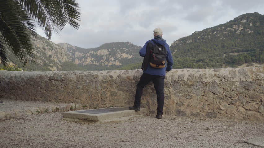 An elderly man watch to the Valdemossa, medieval village, Spain