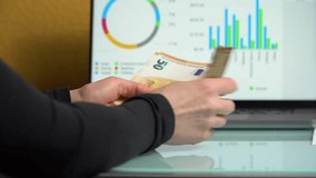 4K close up footage of female hands counting 50 euro  banknotes in front of laptop screen with diagrams. Home finance concept - Powered by Shutterstock - Get 15% off with code: PIKWIZARD15