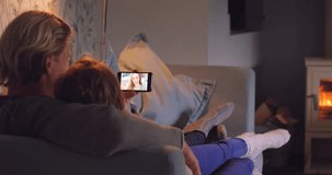Couple, smartphone and screen with living room, video call and relationship for connection or communication. Parents, night and lounge with conversation, bonding and mobile technology for love