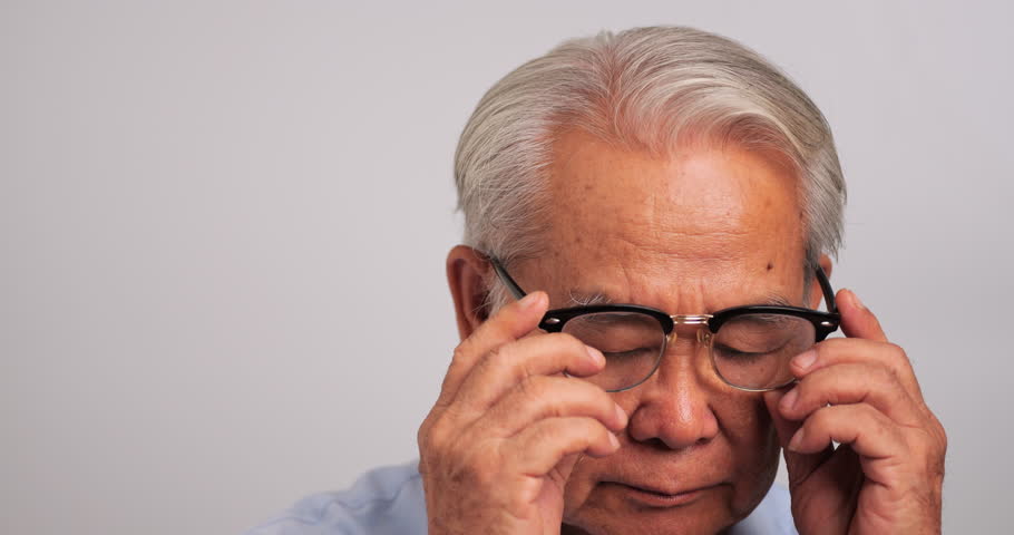 Asian old man was rubbing his eyes, tired of staring for a long time. Elderly man is suffering from eye strain due to his long-time looking at the digital tablet. Royalty-Free Stock Footage #3434054615