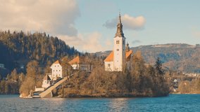 4K video of lake Bled in Slovenia and its famous island in the middle of the lake with a Church. Filmed during the beautiful winter sunny day.