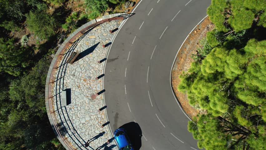Aerial View of a Blue Car On A Curvy Mountain Road Surrounded By A Lush Green Forest, Tenerife, Spain Royalty-Free Stock Footage #3434095367