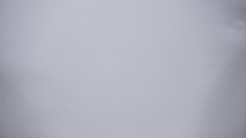 White paper burns from above on a green background copy space. The sheet of paper burns and reveals a green background for pasting.