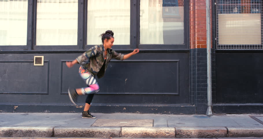 Woman in city, dance with energy and hip hop outdoor, happy with music and creativity for fun. Rhythm, motion and moving on sidewalk, urban and dancer in streetwear with freedom and performance