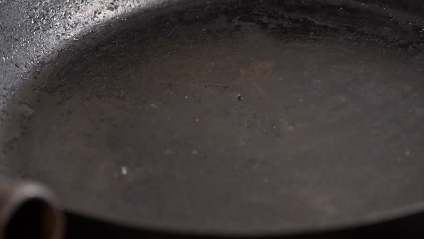 Cooking oil is drizzled into black cast iron skillet, close up view Royalty-Free Stock Footage #3434194301