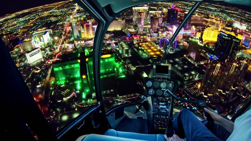 Scenic flight above Vegas skyline by night in the Nevada United States of America. Helicopter cockpit on Las Vegas skyscrapers of downtown with casinos and hotels at night.