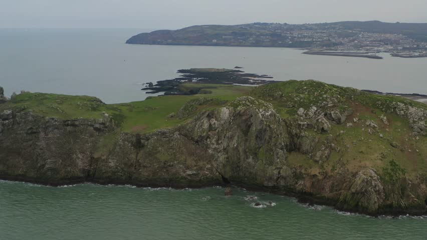 Reverse tracking shot, Ireland's eye cliffside. Howth in background. Royalty-Free Stock Footage #3434252859