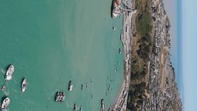Aerial View Of Marina Bay With Fishing Boats Moored At San Antonio Port In Chile. Vertical Video, Orbit Motion