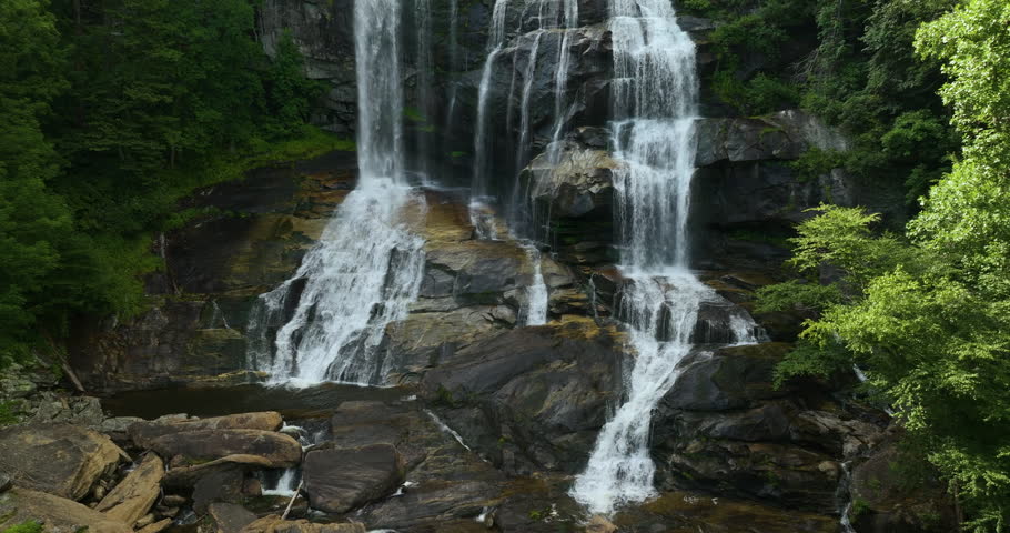 Whitewater Falls with falling down clear water from rocky boulders between green lush woods in Nantahala National Forest, North Carolina, USA