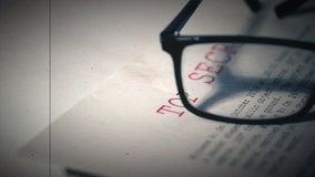 Top secret document with pair of glasses in damaged film vintage style zoom dolly selective focus - Powered by Shutterstock - Get 15% off with code: PIKWIZARD15