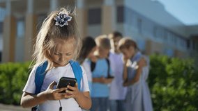 Close-up portrait of a child with smartphone.group of children in schoolyard are watching video on smartphone online.modern technologies.children communicate via video with family.happy family concept