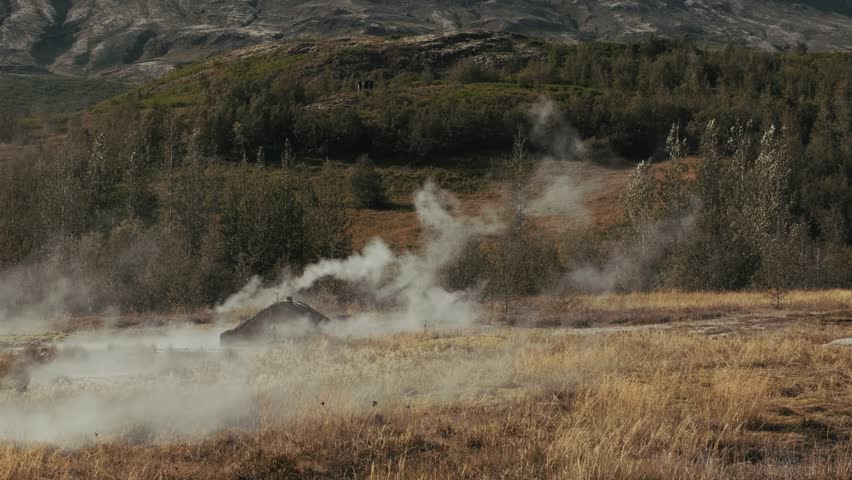 Hot steam rising from small smidur Geysir boiling geothermal hot spring water boiling on golden circle, strokkur Iceland