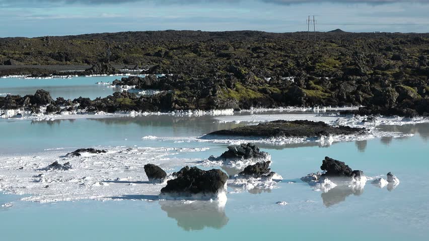 Blue Lagoon. Geothermal hot spring. Blue waters contrasting with black ground. Flying over open natural pool. High quality. Iceland