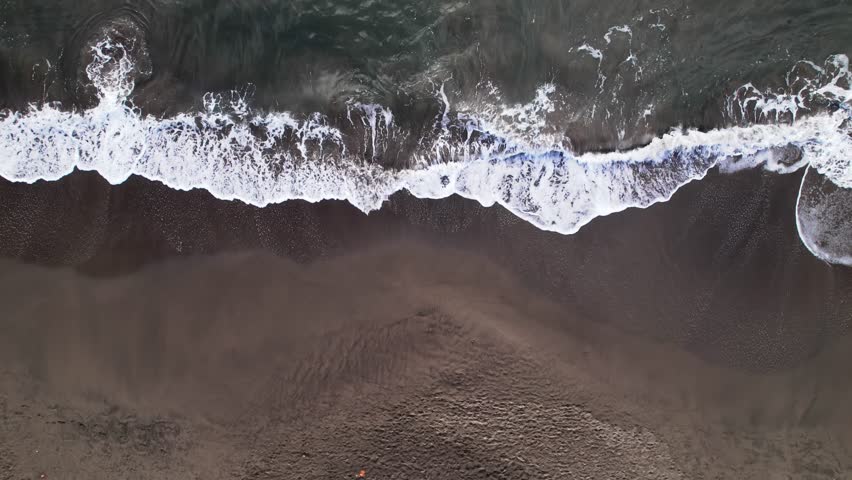 People walking on Caribbean beach, Plage de Grande Anse bay, Trois Rivieres in Guadeloupe. Aerial drone directly above