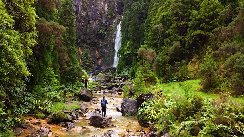 Waterfall in Sao Miguel, Azores. Track of water fall amidst beautiful nature . Tourists hike, trail pathway and routes following river.