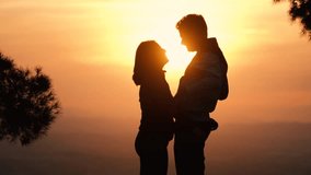 Silhouette of kissing couple against sunset at mountain top. Romantic scene of lovers kiss. Romance and activities for in love people in Saint Valentine's Day, Spain.. - Powered by Shutterstock - Get 15% off with code: PIKWIZARD15