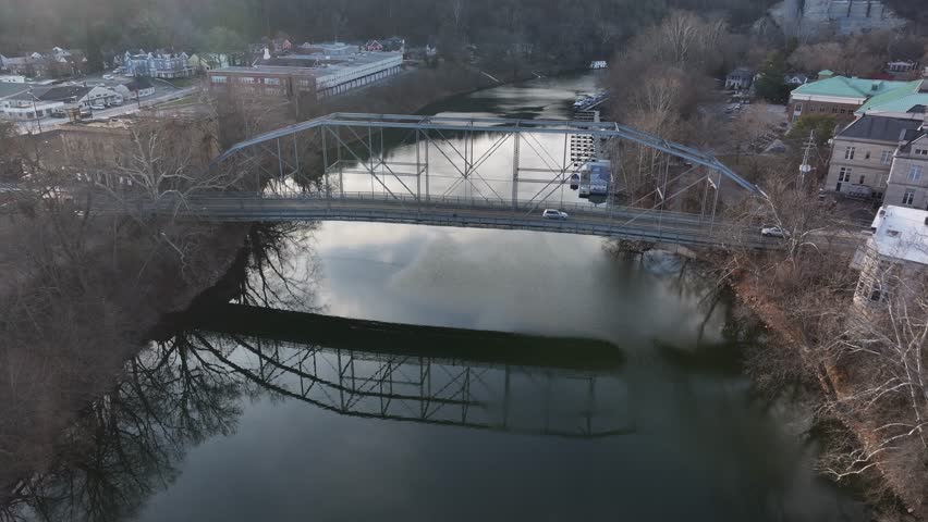 singing bridge over the Kentucky ohio river in downtown Frankfort Kentucky during sunset with cars driving over AERIAL DOLLY