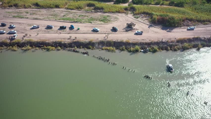 migrants crossing the Rio Grande into Eagle Pass, Texas. interaction between migrants and the Border Patrol, The video also showcases the presence of barbed wire along the border