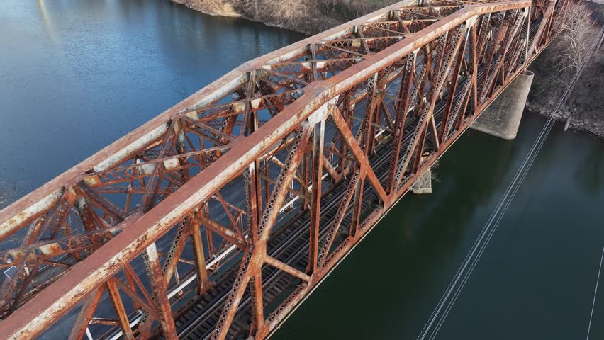 old RJ Corman Railroad Bridge in downtown Frankfort Kentucky during sunset with a sun flare AERIAL TRUCKING