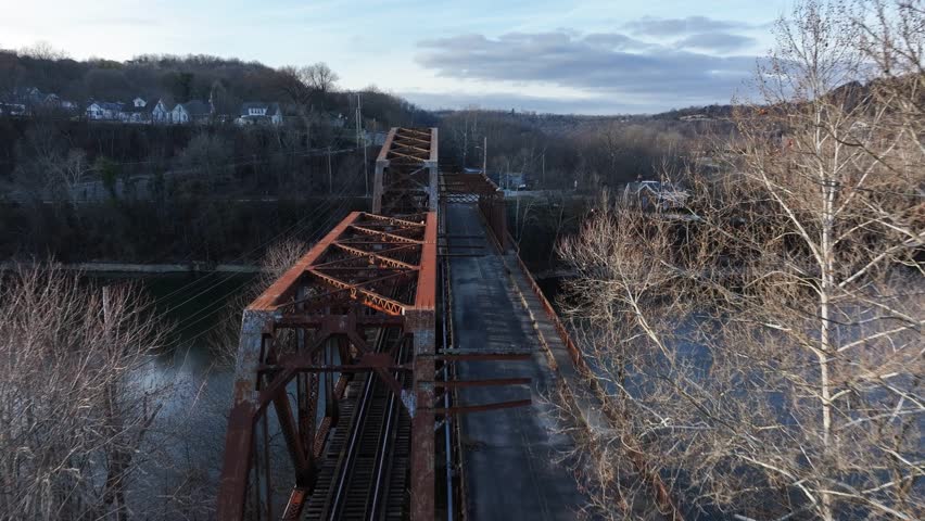 old RJ Corman railroad bridge in downtown Frankfort Kentucky during Sunset with a sun flare AERIAL DOLLY PAN