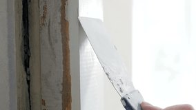 Closeup slow motion video of removing old paint from wooden door with spatula