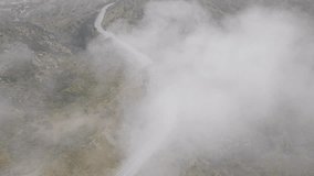 Overhead view of cloud formation over Kanan road, Malibu, Los Angeles suburban, California, USA. Birds eye view of autos moving fast through the tunnel in Santa Monica Mountains in mist, 4k footage