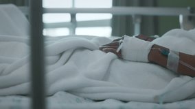Close up shot of IV drip solution in a preteen patient's hand while lying down on bed in hospital. Healthcare and Medical treatment concept. Slow motion shot. - Powered by Shutterstock - Get 15% off with code: PIKWIZARD15