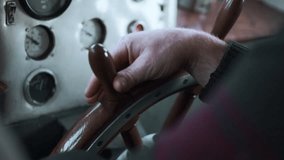 The ship's captain turns the wheel of the ship. Clip. Close up of man hand turning wooden steering wheel. - Powered by Shutterstock - Get 15% off with code: PIKWIZARD15